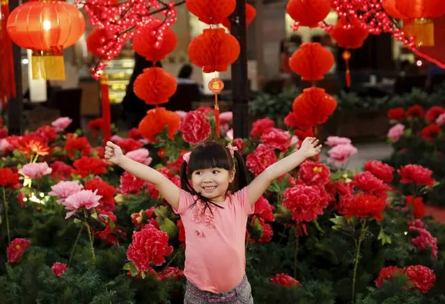 Grace Chee, 4, poses for photographs in front of Chinese New Year decorations in one of Kuala Lumpur's largest shopping malls, in this January 28, 2015 file photo. (Photo by Olivia Harris/Reuters)