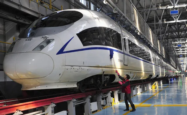 A worker cleans a CRH380B high-speed Harmony bullet train as it stops for an examination during a test run, at a bullet train exam and repair center in Shenyang, Liaoning province Tuesday, October 23, 2012. (Photo by Reuters/Stringer)