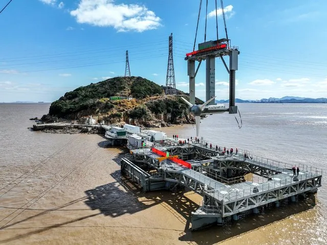 Aerial view of workers setting up a 1.6-megawatt tidal current power generator, the world's largest single-unit capacity, in the sea near Xiushan Island on February 24, 2022 in Zhoushan, Zhejiang Province of China. (Photo by Yao Feng/VCG via Getty Images)