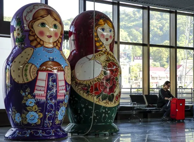 A woman sits next to giant matryoshka dolls inside a terminal of Sochi's airport in Adle, Russia, July 13, 2015. Russia will host the World Cup soccer tournament for FIFA in 2018. (Photo by Maxim Shemetov/Reuters)