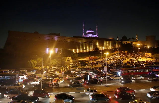 People and vehicles are seen caught in a traffic jam in front of the Saladin Citadel during the opening of 25th Citadel Festival for Music and Singing which is organized by the Cairo Opera House with the participation of artists from different Arab countries in Cairo, Egypt August 18, 2016. (Photo by Amr Abdallah Dalsh/Reuters)