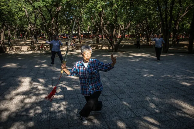 Chinese people practice Tai Chi moves at a park in Beijing, China, 07 May 2017. Tai Chi is an internal Chinese martial art practiced for both its defense training and its health benefits. (Photo by Roman Pilipey/EPA)