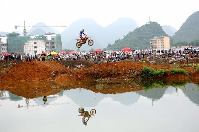 A rider rides a motorcycle in the air during a competition at Guilin, Guangxi Zhuang Autonomous Region, China May 20, 2017. (Photo by Reuters/Stringer)