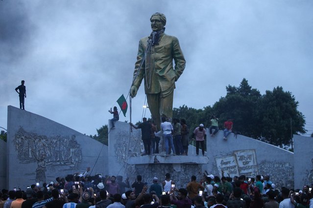 Anti-government protestors attempt to vandalise a statue of Sheikh Mujibur Rahman, Bangladesh's founding father and parent of the country's ousted Prime Minister Sheikh Hasina, in Dhaka on August 5, 2024. Bangladeshi Prime Minister Sheikh Hasina's 15-year rule ended on August 5, as she fled after more than a month of deadly protests as the military announced it would form an interim government. (Photo by Abu Sufian Jewel/AFP Photo)