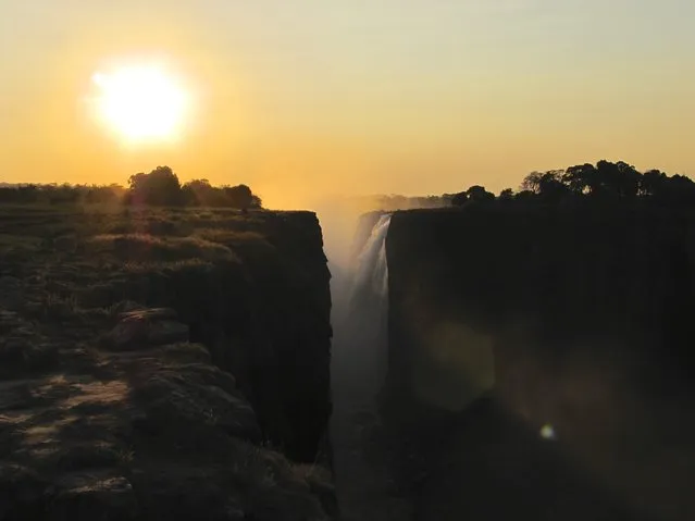 “Sunset at Victoria Falls”. As I walked along the trail thinking how perfect it was to have the sun behind me for my pictures of Victoria Falls, you can imagine my surprise when I turned around to exit the park before darkness arrived. The sun illuminated the falls from behind highlighting the blackness of the canyon where the falls were spilling into. Photo location: Victoria Falls, Zimbabwe, Africa. (Photo and caption by Thomas Burke/National Geographic Photo Contest)