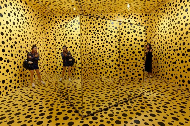 Visitors  stand inside an installation by Japanese artist Yayoi Kusuma titled “The Spirits of the Pumpkins Descended into the Heaven” during a media preview at National Gallery Singapore on June 6, 2017. Over 120 works from Japanese artist Yayoi Kusama's titled “YAYOI KUSAMA: Life is the Heart of a Rainbow” will be on exhibit at National Gallery Singapore from June 9 to September 3. (Photo by Roslan Rahman/AFP Photo)