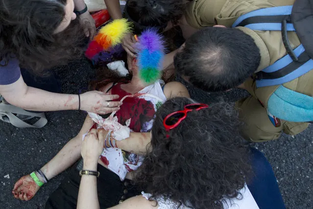 Paramedics help a wounded woman after an ultra-Orthodox Jew attacked people with a knife during a Gay Pride parade Thursday, July 30, 2015 in central Jerusalem. (Photo by Sebastian Scheiner/AP Photo)