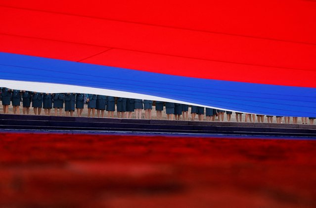 Participants hold a large-size Russian state flag during celebrations of National Flag Day in Moscow, Russia on August 22, 2024. (Photo by Maxim Shemetov/Reuters)