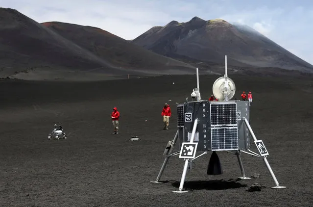 Scientists from German Aerospace Center are seen working as they test some robots on the Mount Etna, Italy on July 4, 2017. Mount Etna, in Sicily, is a test bed for the approximately three-foot high, four-wheeled machine ahead of a future mission to the moon. It is being conducted by the German Aerospace Centre, the agency which runs Germany's space program. The program has enlisted experts from Germany, Britain, the United States and Italy to research ROBEX (Robotic Exploration of Extreme Environments) with the aim of improving robotic equipment that will be used in space. “This is aimed at simulating a future, hypothetical landing mission on the moon or Mars and they use a lot of robots which are there to transport and install different instruments”, said Boris Behncke, a volcanologist from the National Vulcanology Institute in Catania, near Mount Etna. Scientists also hope to use the robots to explore the depths of Mount Etna and relay back useful technical data on seismic movement. The techniques learned on Etna would then be deployed in lunar missions or in the exploration of Mars. An initial robotic testing phase has nearly been completed on the Piano del Lago area of the volcano, a desolate stretch of terrain buffeted by strong winds. Next, a network of equipment including rover robots and drones will be mounted to monitor seismic activity that closely simulates that which would be used on the moon. (Photo by Antonio Parrinello/Reuters)