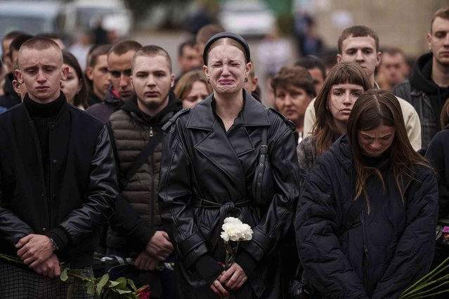 A woman cries during the funeral ceremony of Ihor Kusochek, Ukrainian soldier of the Azov brigade in Bobrovytsia, Chernihiv region, Ukraine, Friday October 4, 2024. (Photo by Evgeniy Maloletka/AP Photo)