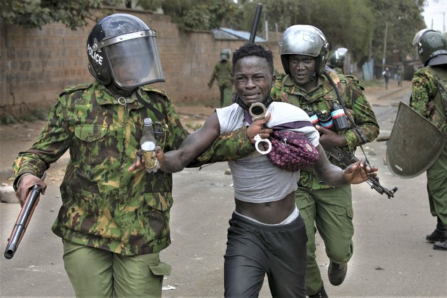 A suspected demonstrator is apprehended by Kenyan police during confrontations between authorities and supporters of the Kenyan opposition during anti-government protests in Nairobi on July 19, 2023. Kenya braced on July 19, 2023 for a new round of protests despite the government warning it would not tolerate further unrest after earlier demonstrations turned violent with more than a dozen people killed. (Photo by Tony Karumba/AFP Photo)