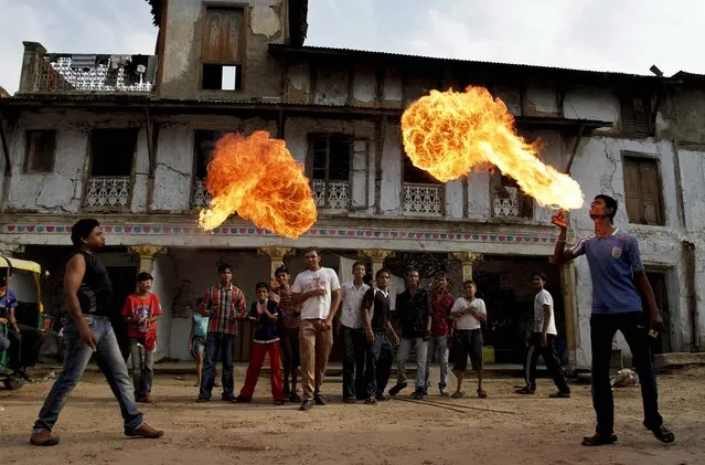 Youths practice fire stunts ahead of the annual Rath Yatra, or Chariot procession of Lord Jagannath, in Ahmadabad, India on June 17, 2012