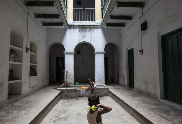 Children of Mukti Bhavan employees play cricket inside its premises in Varanasi, in the northern Indian state of Uttar Pradesh, June 17, 2014. (Photo by Danish Siddiqui/Reuters)