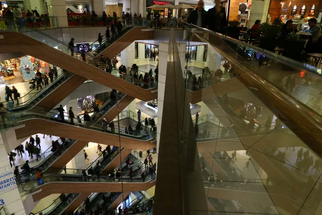 People ride escalators inside a commercial center in Santiago, Chile May 19, 2017. (Photo by Ivan Alvarado/Reuters)