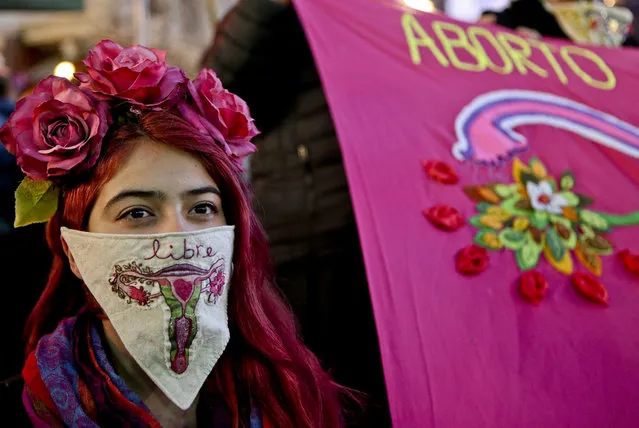 In this Tuesday, July 25, 2017 photo, a woman wearing a handkerchief with an image of an embroidered uterus and the Spanish word for “free”, takes part in a march in favor of a bill backed by President Michelle Bachelet, to legalize abortions in three situations: when the mother's life is in danger, when the fetus is not viable, and in cases of rape, in Santiago, Chile. (Photo by Esteban Felix/AP Photo)