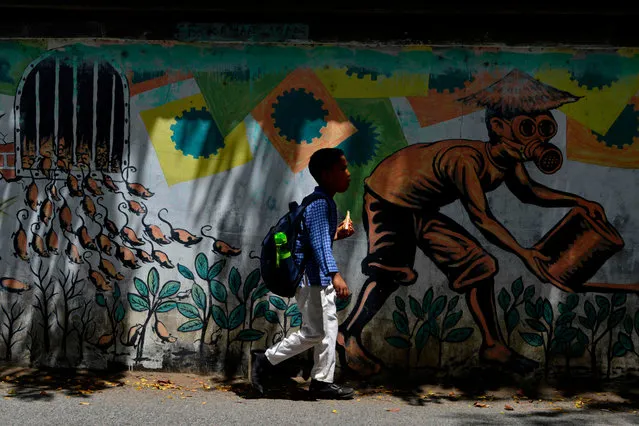 A child passes in front of a mural in Banda Aceh, Indonesia on February 12, 2020. (Photo by Chaideer Mahyuddin/AFP Photo)