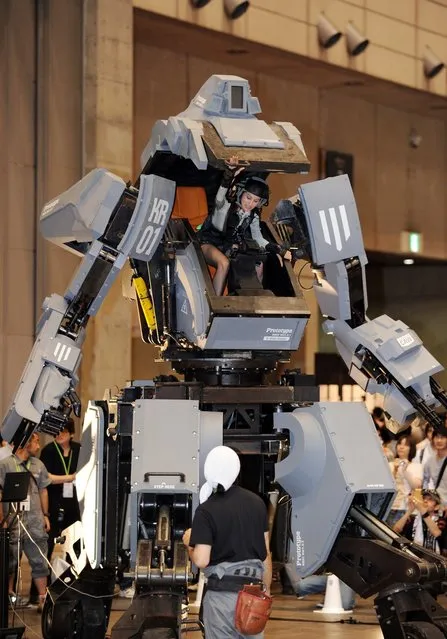 Female “pilot” Anna (C) climbs out the cockpit of Japanese electronics company Suidobashi Heavy Industry's newly unveiled robot “Kuratas” at the Wonder Festival in Chiba, suburban Tokyo on July 29, 2012. The “Kuratas” robot, which will go on sale with a price tag of one million USD, measures four meters in height, weighs four tons and has four wheeled legs that can either be controlled remotely through the 3G network or by a human seated within the cockpit.