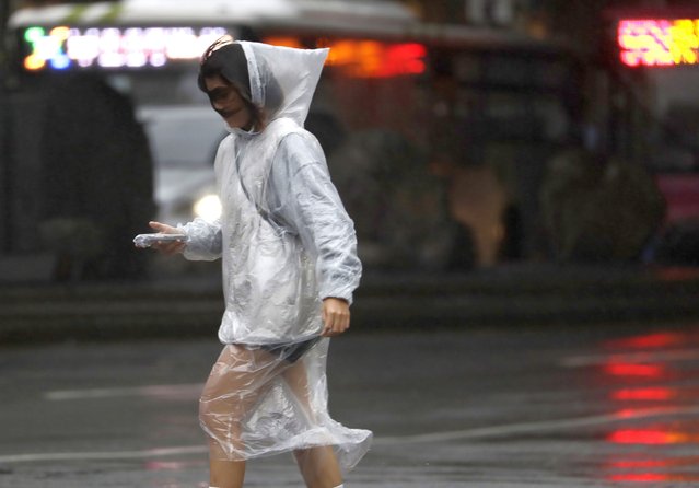 A woman walks in the rain as Typhoon Koinu approaches to Taiwan in Taipei, Taiwan, Wednesday, October 4, 2023. (Photo by Chiang Ying-ying/AP Photo)