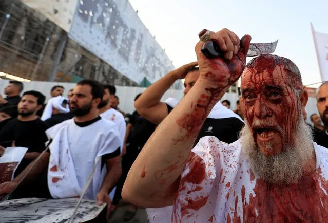 A supporter of Iraqi populist leader Moqtada al-Sadr gashes his head with blade during a ceremony marking Ashura, the holiest day on the Shi'ite Muslim calendar, at Tahrir Square in Baghdad,,Iraq on August 9, 2022. (Photo by Thaier Al-Sudani/Reuters)