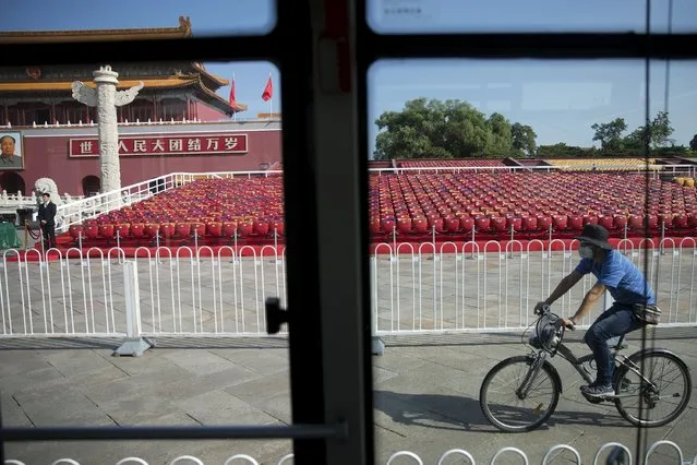 A man cycles past stands raised at Beijing's Tiananmen Square September 2, 2015 as the capital prepares for tomorrow's parade. (Photo by Damir Sagolj/Reuters)