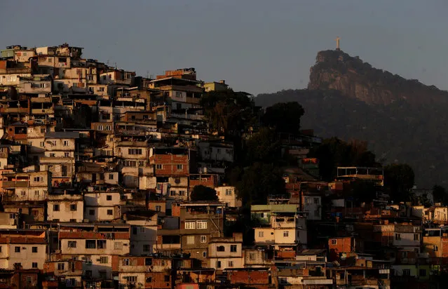 Christ the Redeemer is seen behind Morro da Coroa (Coroa slum) in Rio de Janeiro, Brazil, July 13, 2016. (Photo by Ricardo Moraes/Reuters)