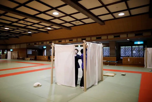 Prefectural staff members prepare for a shelter on the judo rings for those who don't have a stable residence, after places like a 24-hour internet cafes or manga cafes, used as temporary housing have been asking them to leave, after the coronavirus disease (COVID-19) outbreak state-of-emergency was announced at a martial arts stadium in Yokohama, south of Tokyo, Japan on April 13, 2020. (Photo by Issei Kato/Reuters)