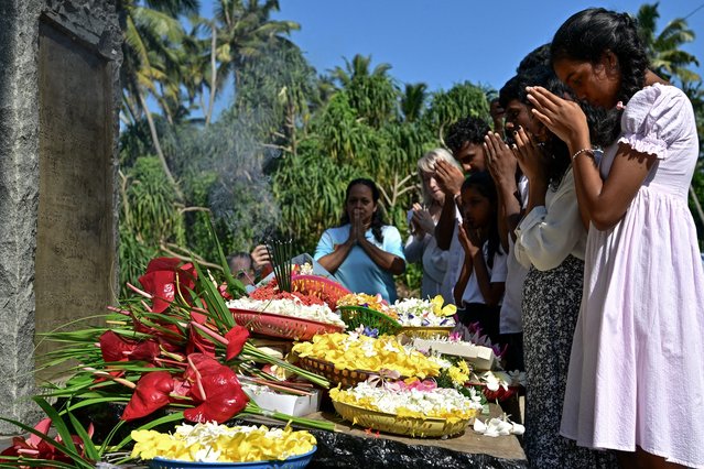 Family members of the victims of the 2004 Indian Ocean tsunami, offer prayers at a memorial monument on the 20th anniversary of the disaster, in Peraliya on December 26, 2024. On December 26, 2004, a magnitude 9.1 earthquake struck the coast of Sumatra in Indonesia and triggered a huge tsunami across the Indian Ocean that killed more than 220,000 people in a dozen countries. (Photo by Ishara S. Kodikara/AFP Photo)