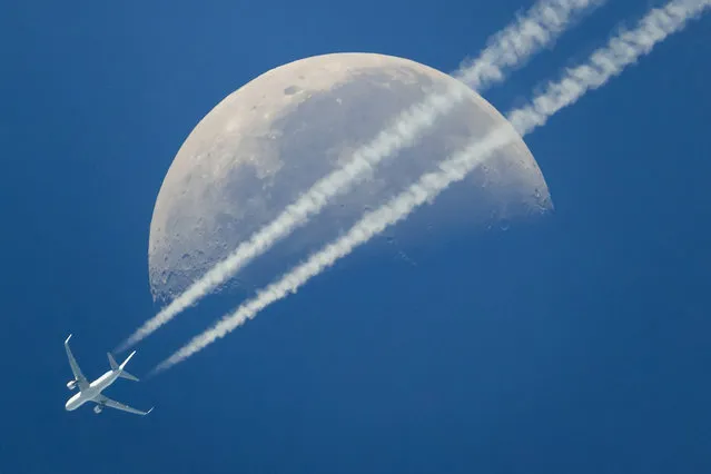 A commercial airplane flies past the moon above Geneva, Switzerland, Saturday, June 17, 2017. (Photo by Valentin Flauraud/Keystone via AP Photo)