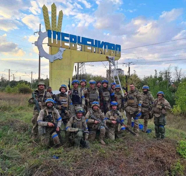 Ukrainian service members pose for in the recently liberated settlement of Vasylenkove, amid Russia's attack on Ukraine, in Kharkiv region, Ukraine, in this handout picture released September 10, 2022. (Photo by Press service of the Territorial Defence of the Ukrainian Armed Forces/Handout via Reuters)