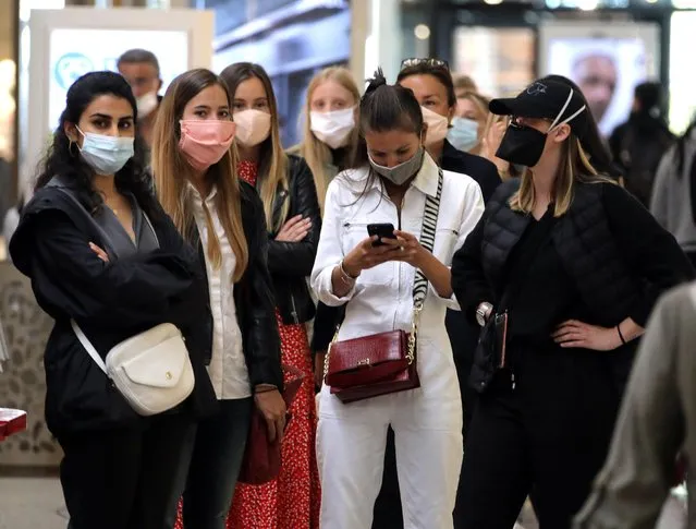 People wearing protective face masks wait to enter in a shop of Cap 3000 department store in Saint Laurent du Var near Nice as France softens its strict lockdown rules during the outbreak of the coronavirus disease (COVID-19) in France, May 11, 2020. (Photo by Eric Gaillard/Reuters)