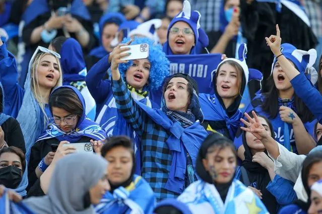 Iranian women fans of Esteghlal football club cheer during a match between Esteghlal and Mes Kerman at the Azadi stadium in the capital Tehran, on August 25, 2022. Iranian women were allowed today to attend a national football championship match for the first time since the 1979 Islamic Revolution, in a “historic” move, local media reported. (Photo by Hossein Zohrevand/TASNIM NEWS via AFP Photo)