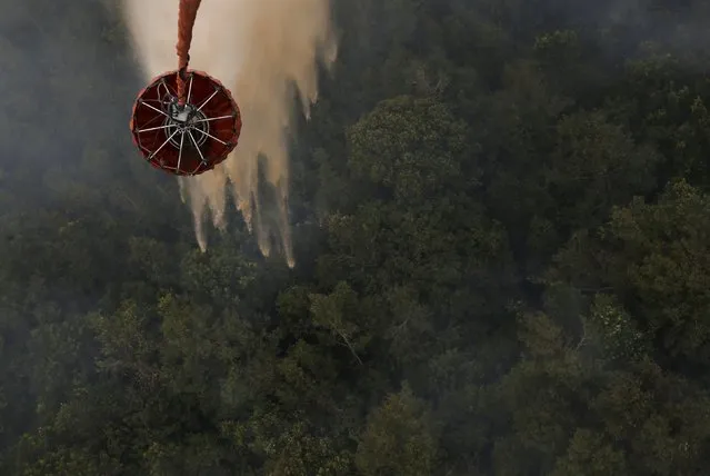An Mi-17 helicopter dumps water on a burning forest at Ogan Komering Ulu area in Indonesia's south Sumatra province September 10, 2015. (Photo by Reuters/Beawiharta)