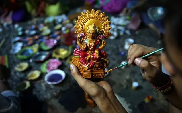 A child, studying under the guidance of Initiative for Viable Education (IVE) for underprivileged children, paints an idol of Goddess Laxmi as he prepares it ahead of Diwali festival in Amritsar, India on October 14,  2017. During Diwali, the earthen lamps are used to illuminate and decorate the entire home and premises, apart from aarti or worship. The Diwali festival will be celebrated on 19 October. IVE is a learning center and non-profit institution working for slum children's education and many of the children studying there work as day laborers, rag pickers or belong to families with low income. Each handmade thing people buy contributes in providing education of an underprivileged child at IVE. (Photo by Raminder Pal Singh/EPA-EFE/Rex Features/Shutterstock)