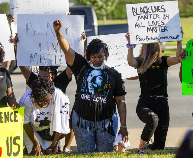 Marchers sit silently for eight minutes at the South Bend Police Station, Tuesday, June 2, 2020, in South Bend, Ind., during a march for justice for George Floyd, who died May 25 after being restrained by police in Minneapolis. (Photo by Michael Caterina/South Bend Tribune via AP Photo)