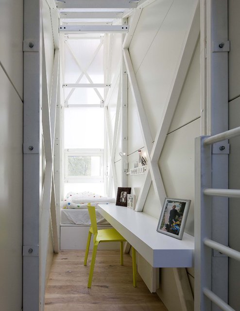 Photos of author Etgar Keret's family rest on a cantilevered desk mounted to the steel structure of the Keret House. (Photo by Andrea Meichsner/The New York Times)
