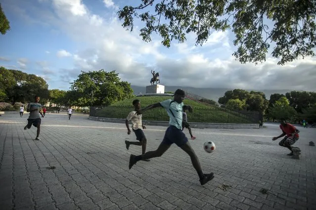 Men play football next to the  Jean Jacques Dessalines monument in Port-au-Prince, Haiti, Wednesday, October 12, 2022. (Photo by Joseph Odelyn/AP Photo)