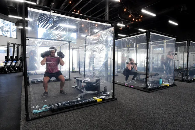 People exercise at Inspire South Bay Fitness behind plastic sheets in their workout pods while observing social distancing on June 15, 2020 in Redondo Beach, California, as the gym reopens today under California's coronavirus Phase 3 reopening guidelines. (Photo by Frederic J. Brown/AFP Photo)