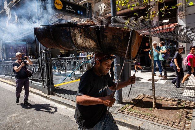 A man carrying a griller on his head takes part in a demonstration near the Argentine Congress during a national strike against the government of Javier Milei in Buenos Aires, on January 24, 2024. Argentine President Javier Milei faces the first national strike in just 45 days of government, against his draconian fiscal adjustment and his plan to reform more than a thousand laws and regulations that governed for decades. The largest Argentine union called the strike in rejection, in particular, of the changes by decree to the labor regime promoted by Milei, which limit the right to strike and affect the financing of unions. (Photo by Tomas Cuesta/AFP Photo)