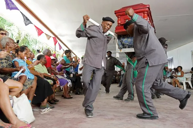 Pallbearers from one of the Surinamese capital's cemeteries dance and sing with a casket during a competition for best performing pallbearers group at the Hodie Mi Cras Tibi funeral hall in Paramaribo, September 20, 2015. (Photo by Ranu Abhelakh/Reuters)