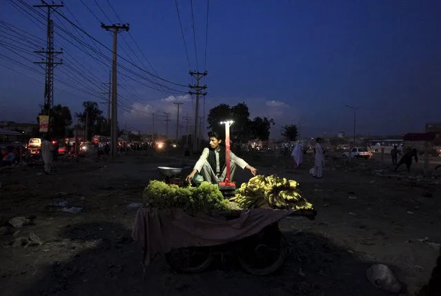 A fruit vendor awaits customers along a roadside in Islamabad, Pakistan,  September 8, 2015. (Photo by Faisal Mahmood/Reuters)