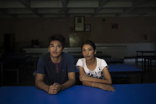 In this Monday, August 18, 2014 photo, Gyalsten, 26, and his sister Kyipa pose in the dining hall of the Tibetan Youth Hostel in New Delhi, India. The duo escaped into India in 2006. Gyaltsen was given the responsibility of taking care of his younger sister. This, he says, has made him a better person. They are afraid that they may never see their parents again. (Photo by Tsering Topgyal/AP Photo)