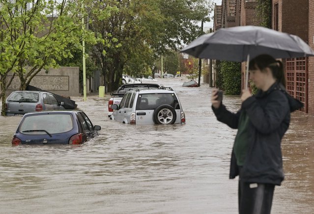 A woman takes pictures in a flooded street after a powerful storm struck the city of Bahia Blanca, 600 km south of Buenos Aires on March 7, 2025. Six people died and hundreds were evacuated in the Argentine port city of Bahia Blanca as torrential rains flooded homes and hospitals, destroyed roads and forced authorities to cut the power. (Photo by Pablo Prest/AFP Photo)