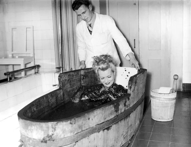 A blonde patient tries a mud bath at the sanitarium in Dachau on December 23, 1948, a German town which is trying to wipe out the memory of the days when it was infamous for its concentration camp. (Photo by AP Photo)
