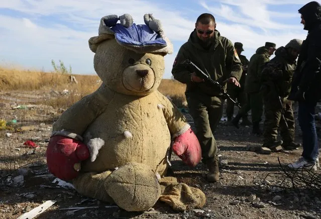 Pro-Russia rebels sappers walk past a giant teddy bear as they search for explosive devices in the destroyed Donetsk international airport on October 13, 2015. Ukrainian forces lost control of the airport in January 2015. (Photo by Aleksey Filippov/AFP Photo)