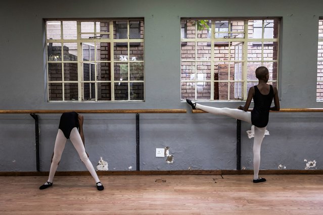 Pupils stretch before a ballet class in Soweto near Johannesburg, on March 20, 2024. Jo-Anne Wyngaard, ballet instructor for Joburg Ballet, conducts classes for children of different ages, skill and social backgrounds in Alexandra, Soweto and in Johannesburg, in hopes of training a new generation of professional dancers to compete at international level. (Photo by Olympia de Maismont/AFP Photo)