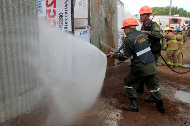 Nicaraguan army members use a hose during a national multi-hazard drill organized by the National System for Prevention, Mitigation and Attention to Disasters (SINAPRED), in the 30 de Mayo neighborhood in Managua, Nicaragua, September 26, 2016. (Photo by Oswaldo Rivas/Reuters)