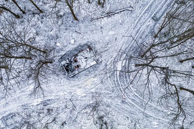 A destroyed Russian tank covered by snow stands in a forest in the Kharkiv region, Ukraine, Saturday, January 14, 2023. (Photo by Evgeniy Maloletka/AP Photo)