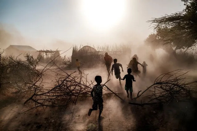 Children and women run among a cloud of dust at the village of El Gel, 8 kilometres from the town of K'elafo, Ethiopia, on January 12, 2023. The last five rainy seasons since the end of 2020 have failed, triggering the worst drought in four decades in Ethiopia, Somalia and Kenya. And the next rainy season, from March to May, is also expected to be below average. According to the UN, drought has plunged 12 million people into “acute food insecurity” in Ethiopia alone, where a deadly conflict has also ravaged the north of the country. (Photo by Eduardo Soteras/AFP Photo)