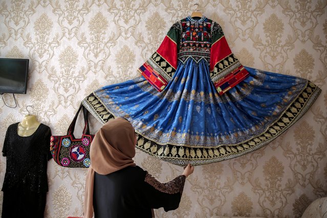 An Afghan woman tailor presents a traditional dress as part of preparations for Eid al-Adha in Kabul, Afghanistan, 02 June 2025. Eid al-Adha, also known as the “Feast of Sacrifice”, is one two main festivals observed by Muslims worldwide, marking the end of the annual Hajj pilgrimage to Mecca. (Photo by Samiullah Popal/EPA)