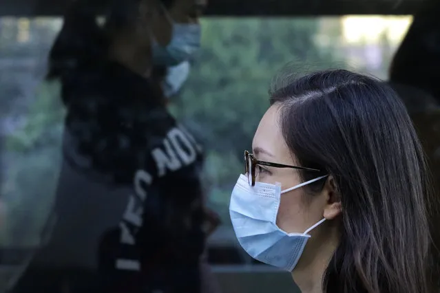 Commuters wearing face masks to help curb the spread of the coronavirus walk out from a subway station in Beijing, Monday, October 19, 2020. (Photo by Andy Wong/AP Photo)